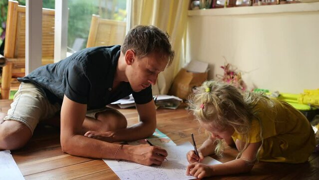 Father draws with his daughter at home