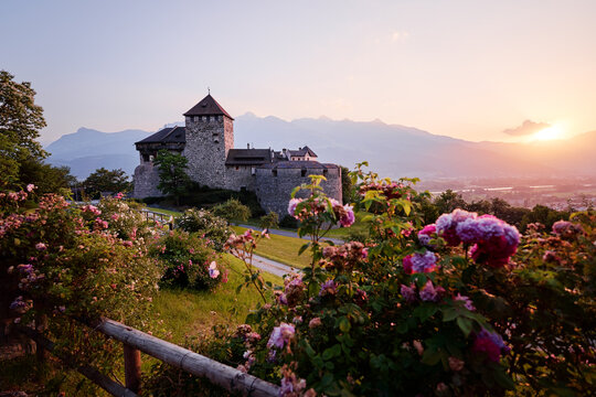 Vaduz Castle, the official residence of the Prince of Liechtenstein, with Alps mountains in background on sunset.