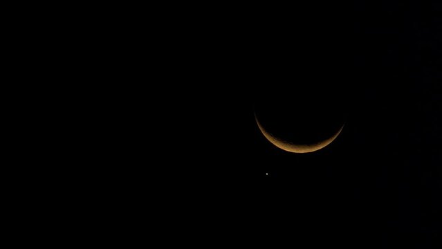 Planet of love Venus sidles up to glowing crescent moon in night sky. Environment World Day concept. Free copy space.
