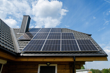 Fototapeta premium olar panels on pitched metal roof. Home Renewable Energy Systems. Solar Rooftop System. Photovoltaic Roofing. 