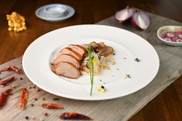 a wooden cutting board topped with a white plate covered in food