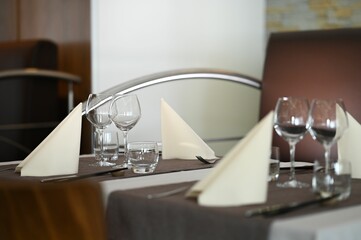 a table topped with a silver metal place setting surrounded by glassware