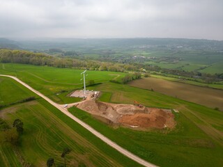Aerial view of a vast expanse of land with T-pylons to connect a nuclear reactor at Hinkley Point