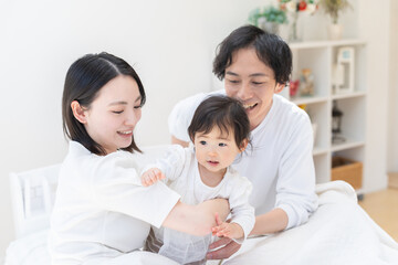 ベッドで赤ちゃんの寝かしつけをする親（家族・ファミリー・親子・睡眠）