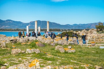 Historical and archaeological heritage of Nora, southern Sardinia, with tourists - obrazy, fototapety, plakaty