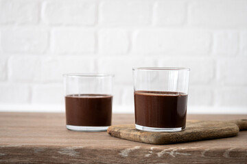 Chocolate mousse dessert garnished with mint leaf on wooden table. Copy space