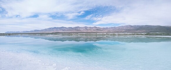Scenic landscape of a tranquil body of water surrounded by distant snow-capped mountains