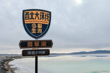 Wooden signpost with Chinese lettering indicating the location of a body of water © Young Hang/Wirestock Creators