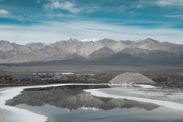 Tranquil scene of a snowy mountain range reflected in the tranquil waters of a frozen lake