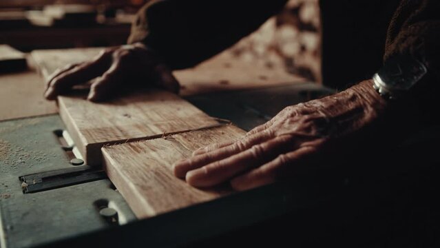 Slow motion of a carpenter cutting wood with a special machine