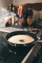 Vertical shot of a person cooking over the stove at home