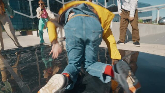 Young And Athletic B-Boy Breakdancing To Break Beats On The City Street In The Circle Of Friends. Group Of Fashionable Young People Supporting Professional Performer, Filming On The Smartphone.