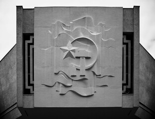 Grayscale of a monument with communism logo on it