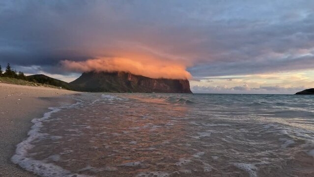 Seascape with Mount Gower in the horizon of sandy beach at sunset