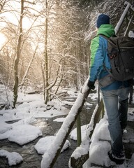 Male figure standing on the snow covered stairs in the forest, exploring