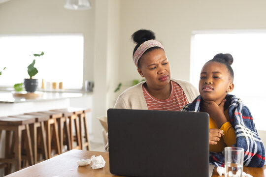 African american mother and daughter using laptop for online consultation with doctor