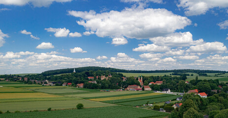 Fototapeta na wymiar Panorama of a spring field with a view of cumulus clouds and the Polish countryside.