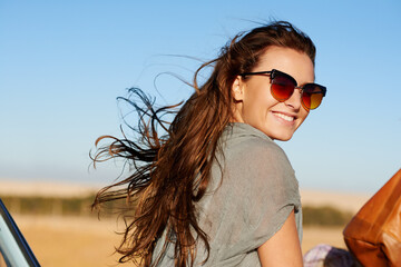 Travel, road trip and young woman with sunglasses for a summer vacation or weekend adventure. Happy, smile and female person having fun with freedom while in nature for an outdoor holiday or journey.