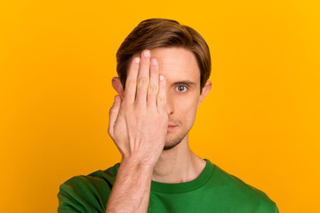 Portrait of man covers half face with palm keeps eyes feels cheerful wears casual jumper isolated over bright background