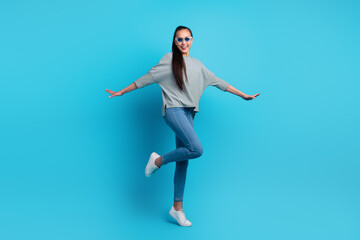 Fototapeta na wymiar Full length body size photo of pretty cheerful carefree girl having fun dancing isolated over blue color background