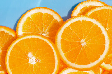 Creative summer composition made of sliced orange closeup on blue background. Freshness concept. Healthy food and vitamin theme. Top view