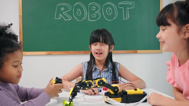 Smart primary students grouping to learning robot free electives with female teacher in classroom. Caucasian teacher female teach childrens assemble robot in science subject at elementary school.
