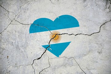 The symbol of the national flag of Argentina in the form of a heart on a cracked concrete wall.