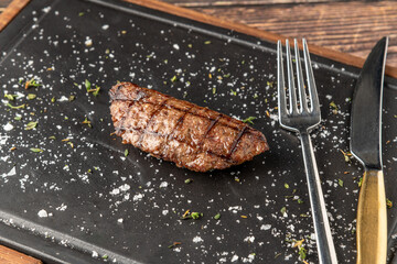 Meatball with grilled cheddar on stone cutting board in steakhouse restaurant