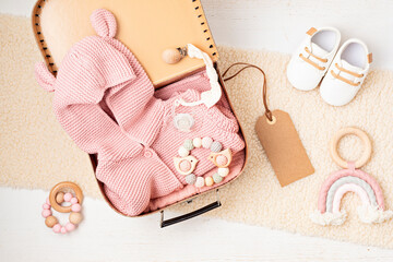 Gift basket with gender neutral baby garment and accessories. Care box of organic newborn booties, fashion, branding, small business idea. Flat lay, top view