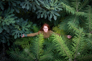 Girl with eyes closed standing amidst plants