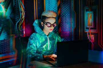 Gamer wearing eyeglasses playing video games on laptop at desk