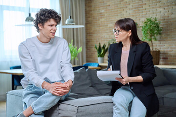 Young guy in therapy discussing his problems with female psychotherapist