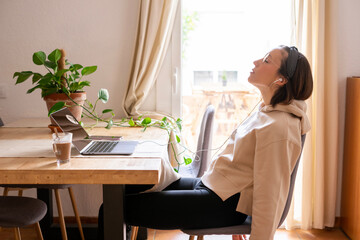girl working at home. Girl leaning on the chair and letting her arms drop from exhaustion