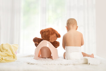 Baby and his teddy bear have training on potty.