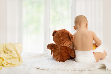 Baby sitting with teddy bear