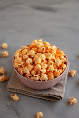 Homemade Cheese Popcorn in a Bowl on a gray background, side view. Copy space.