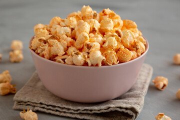 Homemade Cheese Popcorn in a Bowl on a gray background, side view.