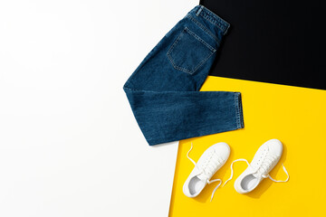 Jeans and white sneakers on colored background