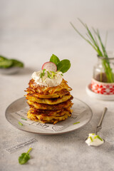Potato pancakes draniki. Vegetable fritters, latkes, hash browns. Vegetable pancakes with sour cream and scallion. Traditional belarusian cuisine.