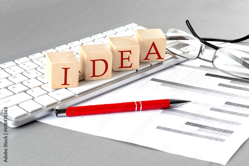 Fototapete IDEA written on a wooden cube on the keyboard with chart on grey background