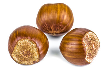 Three ripe hazelnuts on white background