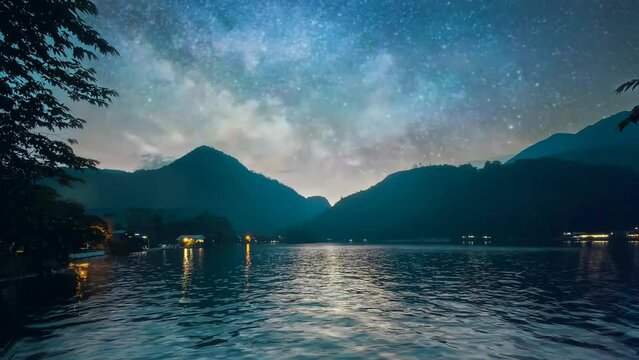 In twilight footage of the night, a peaceful lake mirrors the splendor of the Milky Way as a shooting star gracefully traverses the sky