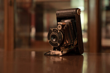 Old/ vintage film photo camera on a wooden table.