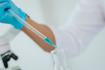 Close-up shot of male doctor using dropper in laboratory