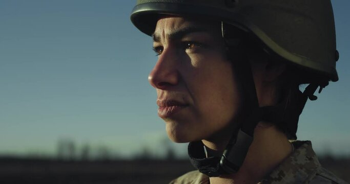 Cinematic Close Up Portrait of Young Female Patriotic Army Soldier with Helmet Saluting in an Open Field During Sunset. Dedicated Woman in Camouflage Military Uniform Ready to Serve her Country