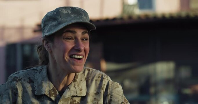 Slow Motion Portrait of Young Happy Female Soldier Hugging and Kissing her Daughter After Returning Back Home From a Mission. Mother in Camouflage Military Uniform Showing Affection to her Little Girl
