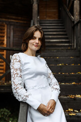 bride on a wooden staircase. wedding day in autumn.