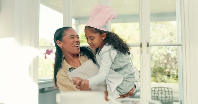 Sing, dance and mother baking with her kid in the kitchen while preparing a meal, supper or dinner. Happy, smile and young mom cooking, bonding and dancing to music with her girl child at their home.
