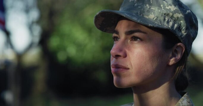 Close Up Portrait of Young Female Patriotic Soldier Saluting with the British Flag in the Background. Dedicated Woman in Camouflage Military Uniform Reporting for Duty, Showing Loyalty to Her Country