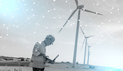 Engineer using laptop for wind turbine inspection; light effect